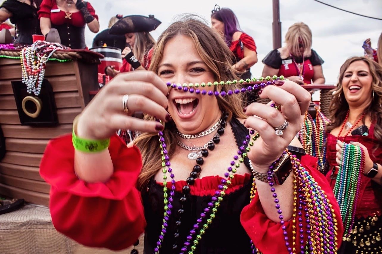 Woman celebrating with colorful beads and costume.