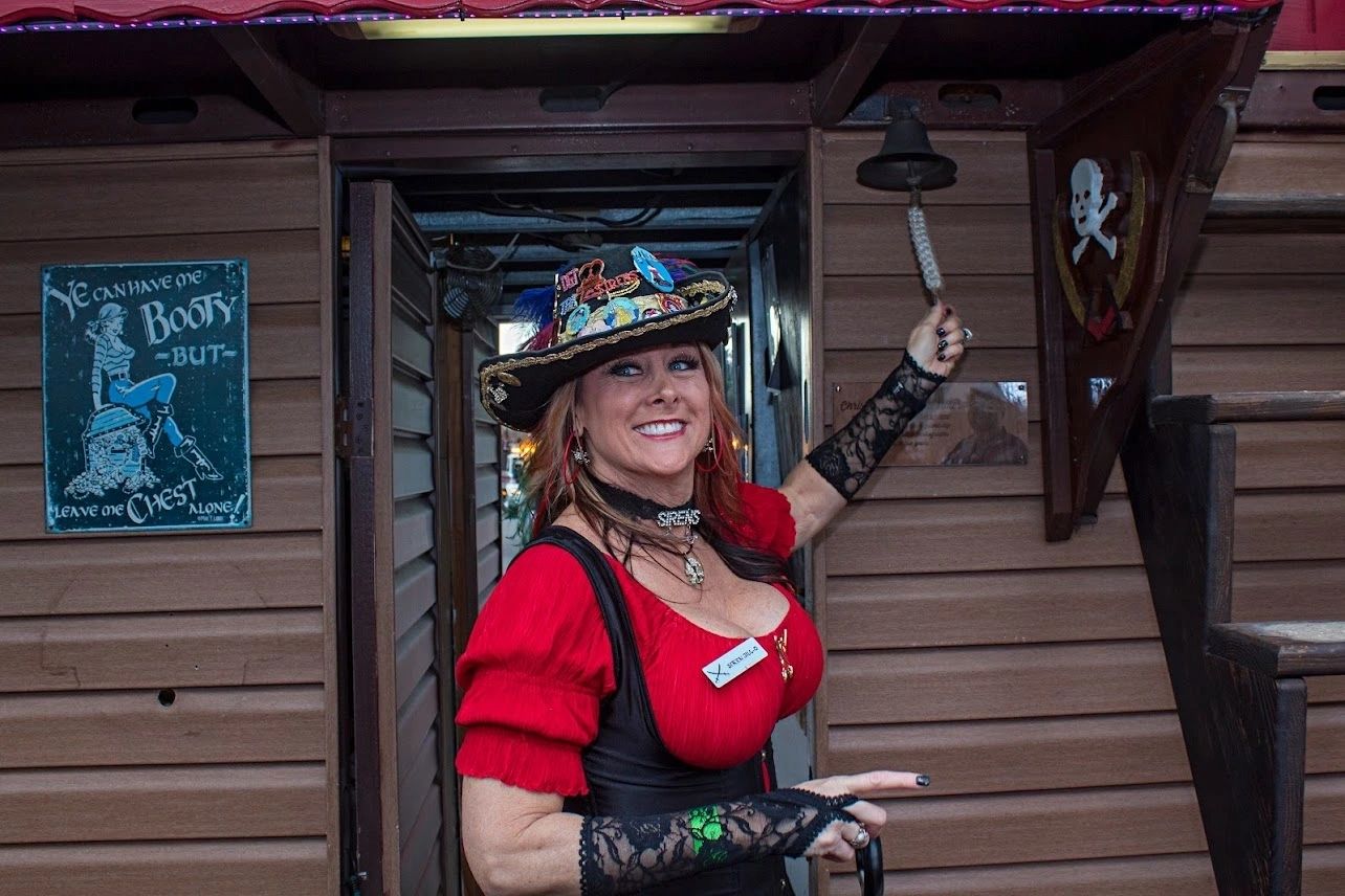 Woman in pirate costume ringing bell.