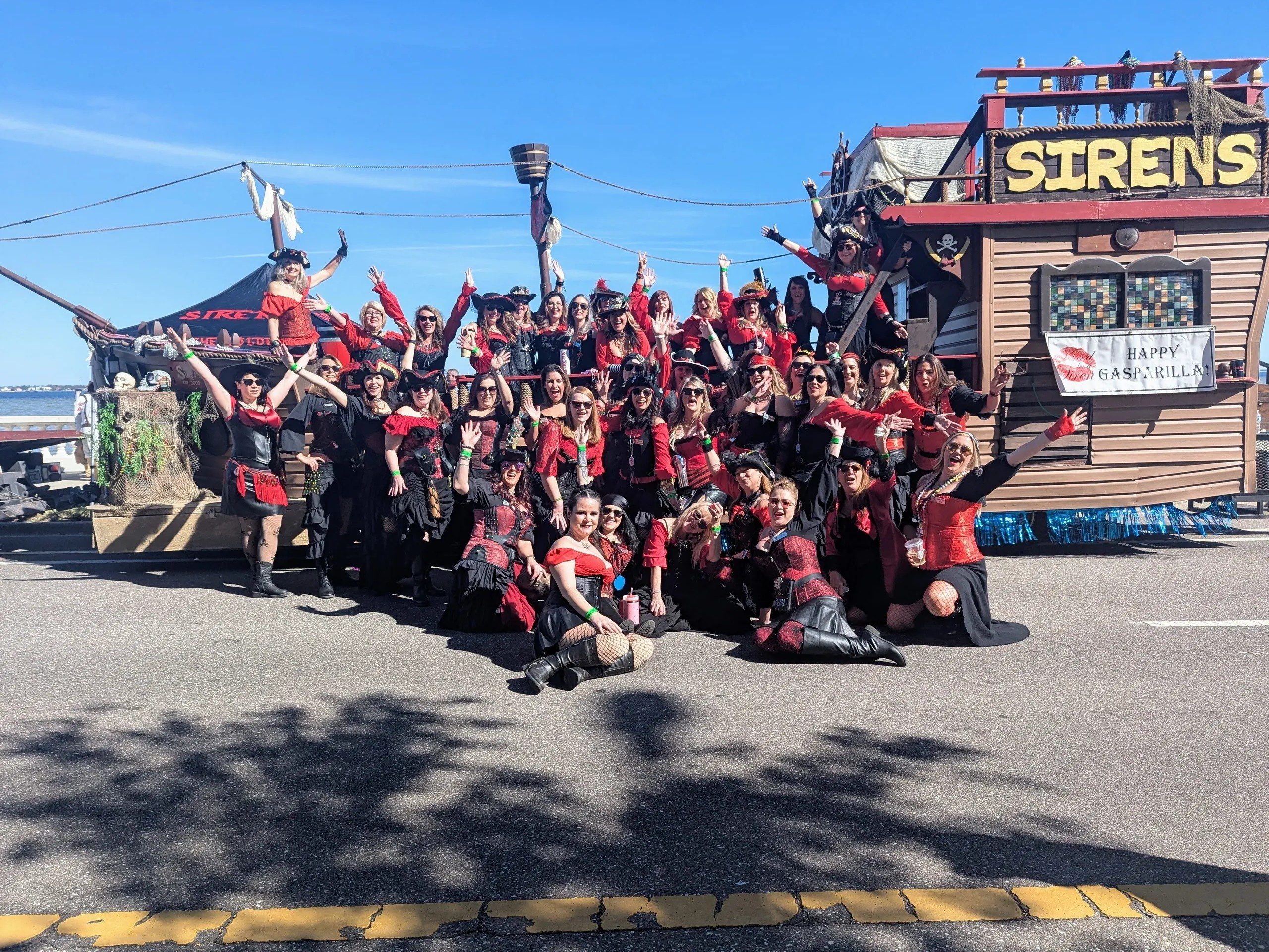 Group posing in pirate costumes, outdoor setting.