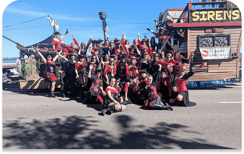 Group posing in pirate-themed costumes outdoors.