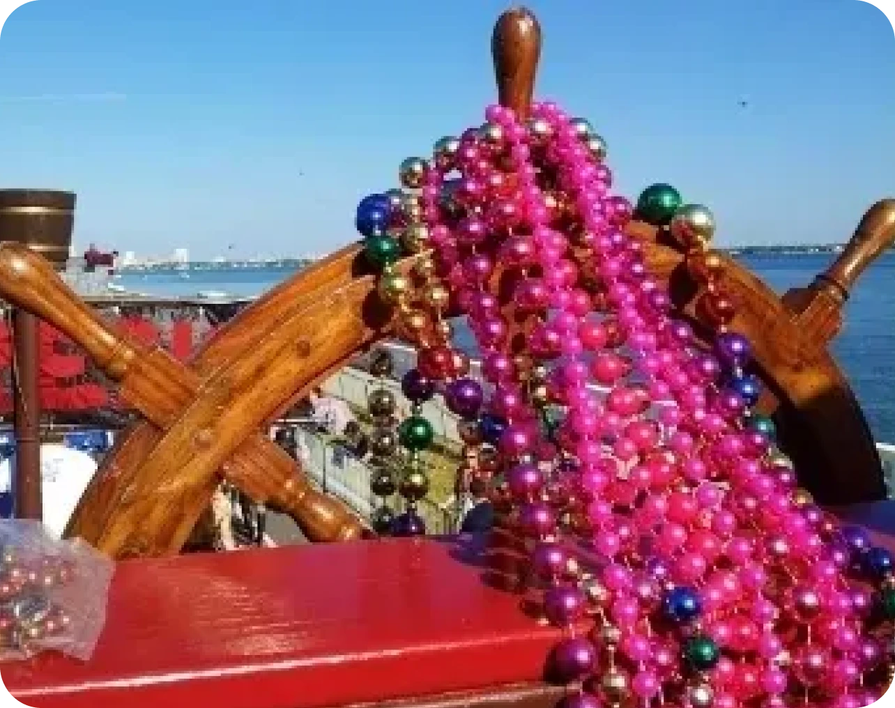 Colorful beads on a ship's wooden wheel.